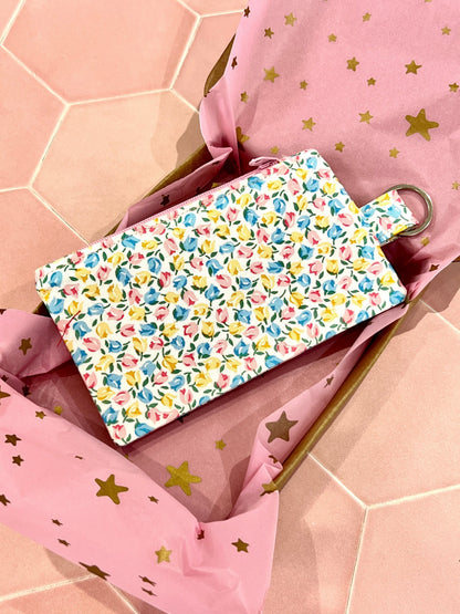 Sew Much Love coin purse with a white base and a tiny floral print in pink, yellow, and blue. Features a keyring attachment.