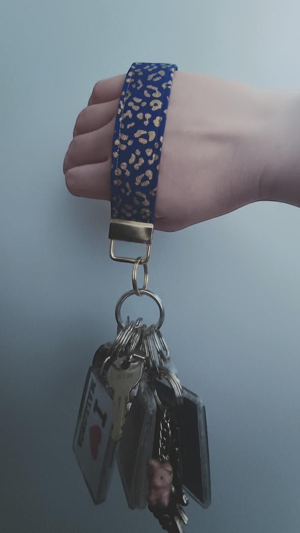 Sew Much Love blue and gold leopard print cotton wristlet keychain with keys attached.