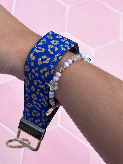 Sew Much Love blue and gold leopard print cotton wristlet keychain with gold hardware.