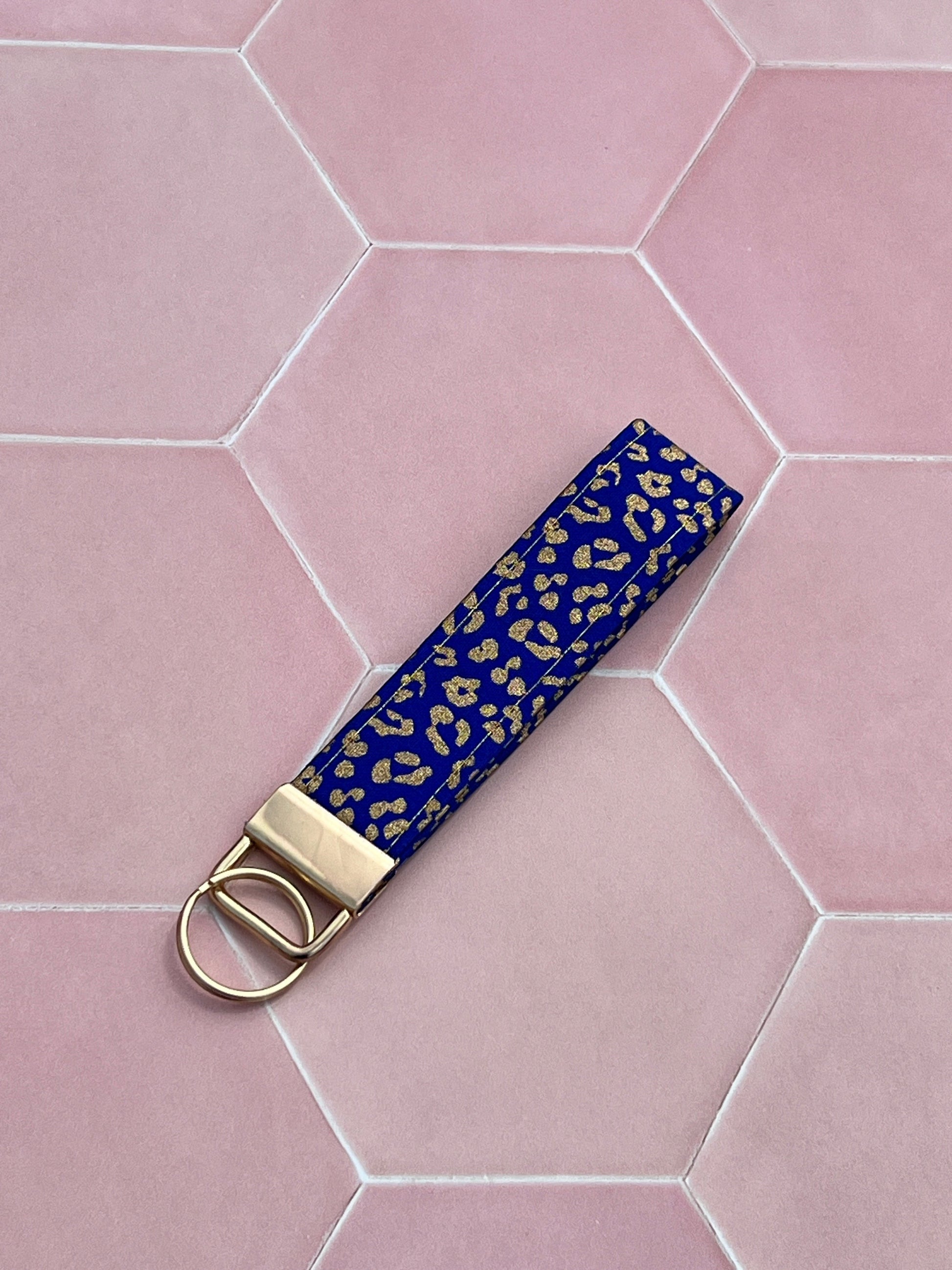 Sew Much Love blue and gold leopard print cotton wristlet keychain with gold hardware.