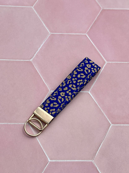 Sew Much Love blue and gold leopard print cotton wristlet keychain with gold hardware.