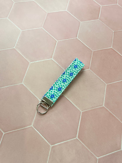 Sew Much Love blue and green floral cotton wristlet keychain with silver hardware.