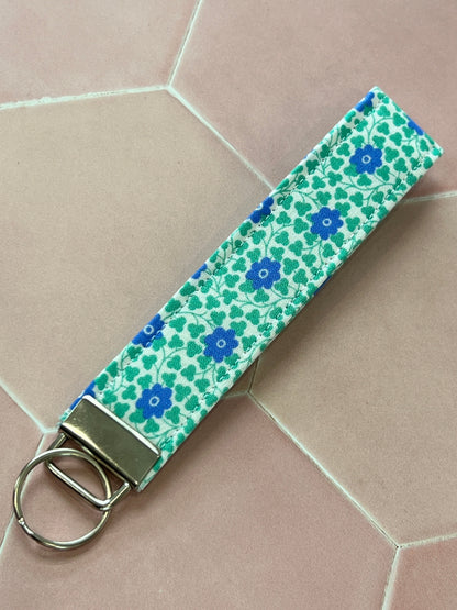 Sew Much Love blue and green floral cotton wristlet keychain with silver hardware.