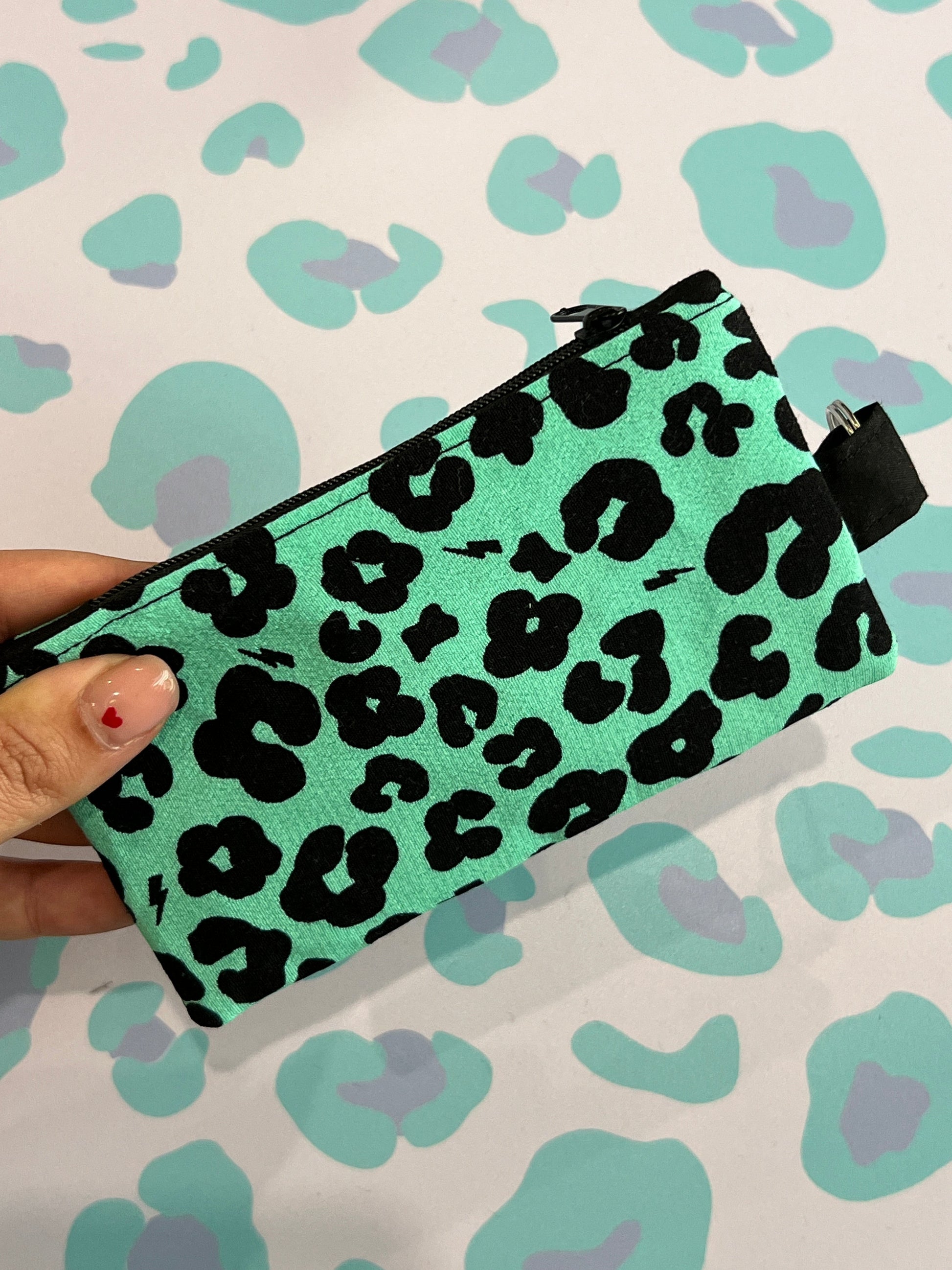 Sew Much Love green coin purse with black leopard print and lightning bolt accents. Features a black zipper and keyring attachment.