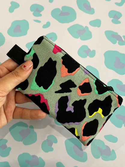 Sew Much Love limited edition coin purse with a grey base and a colourful leopard print in black, pink, green, yellow, and purple. Features a black zip and keyring attachment.