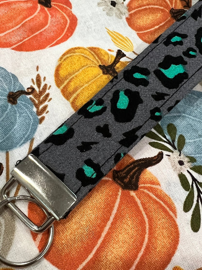 Sew Much Love grey wristlet keychain with black and teal snow leopard print, silver hardware.