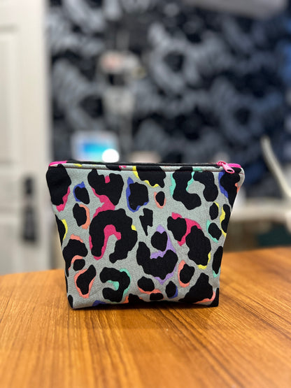 Sew Much Love mini cosmetic bag with khaki, black, pink, blue, yellow, and purple rainbow leopard print. Features a pink zipper pull.