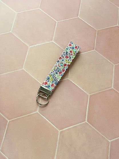 Sew Much Love handmade cotton wristlet keychain with a small floral print in blue, red, and yellow.
