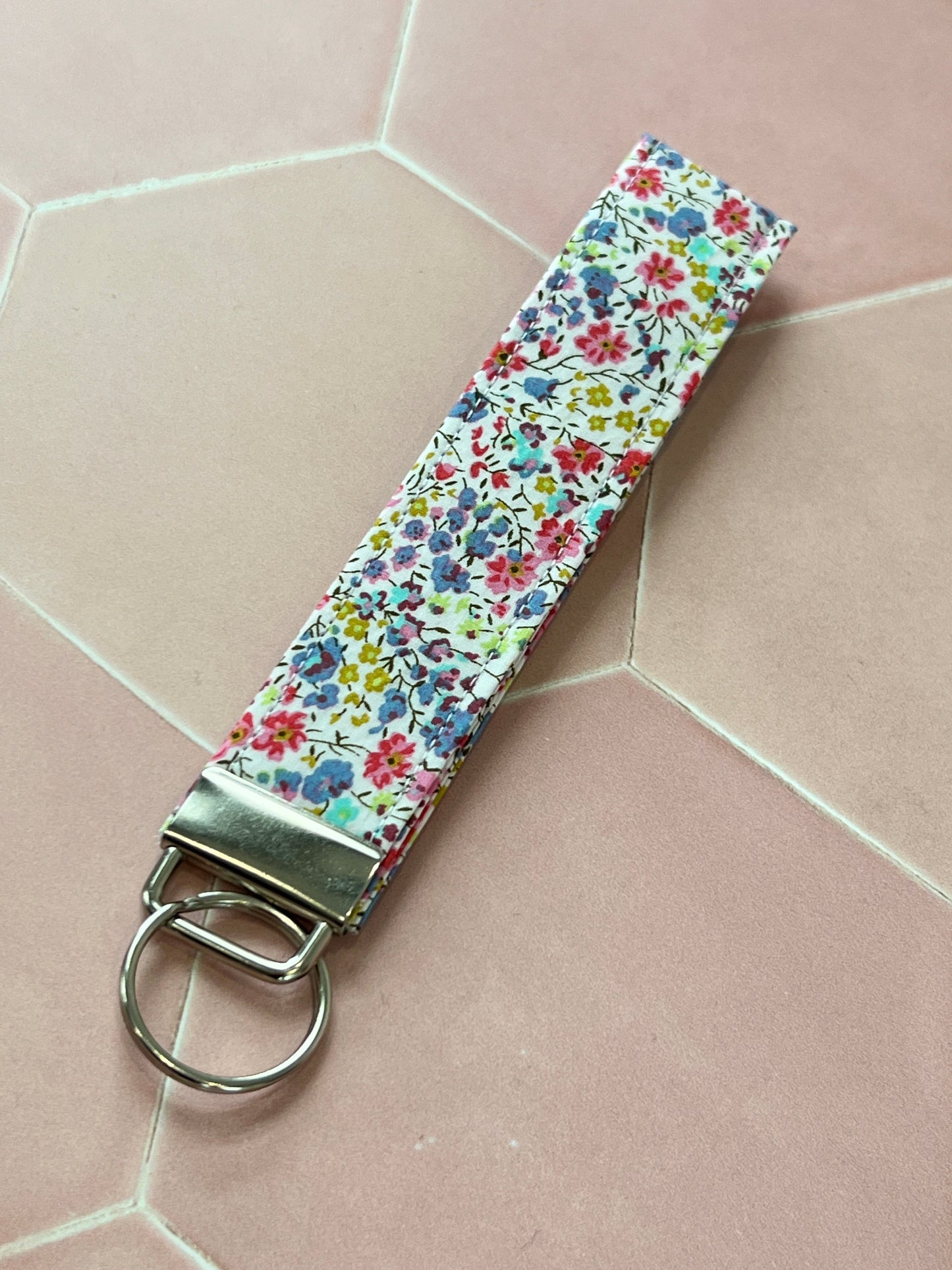 Sew Much Love handmade cotton wristlet keychain with a small floral print in pink, blue, and yellow.