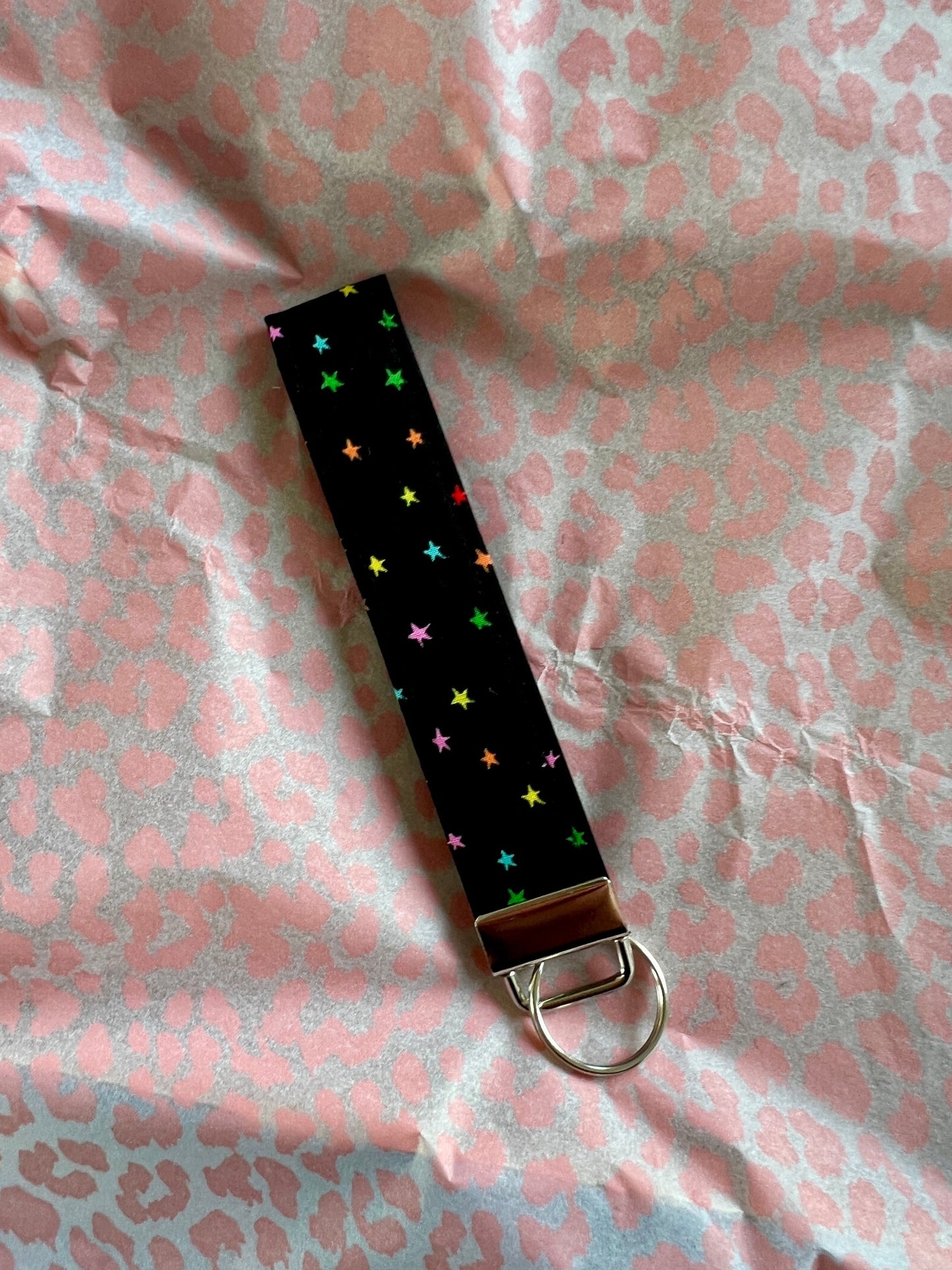 Sew Much Love black fabric wristlet keychain with vivid rainbow stars and silver hardware.