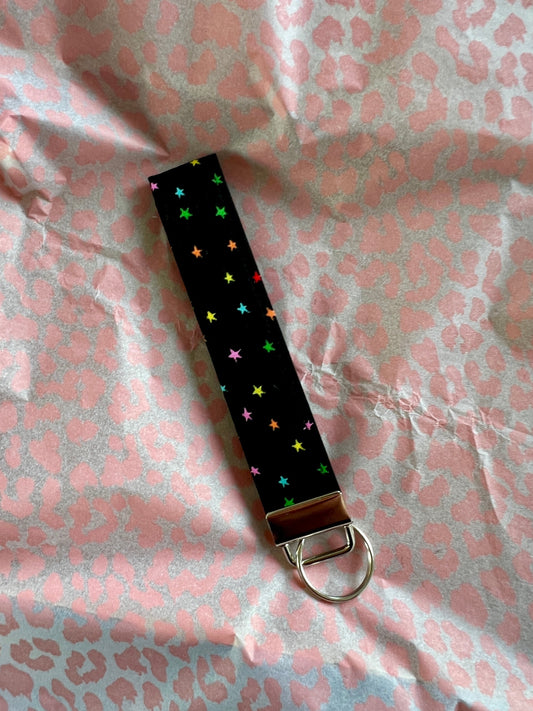 Sew Much Love black fabric wristlet keychain with vivid rainbow stars and silver hardware.