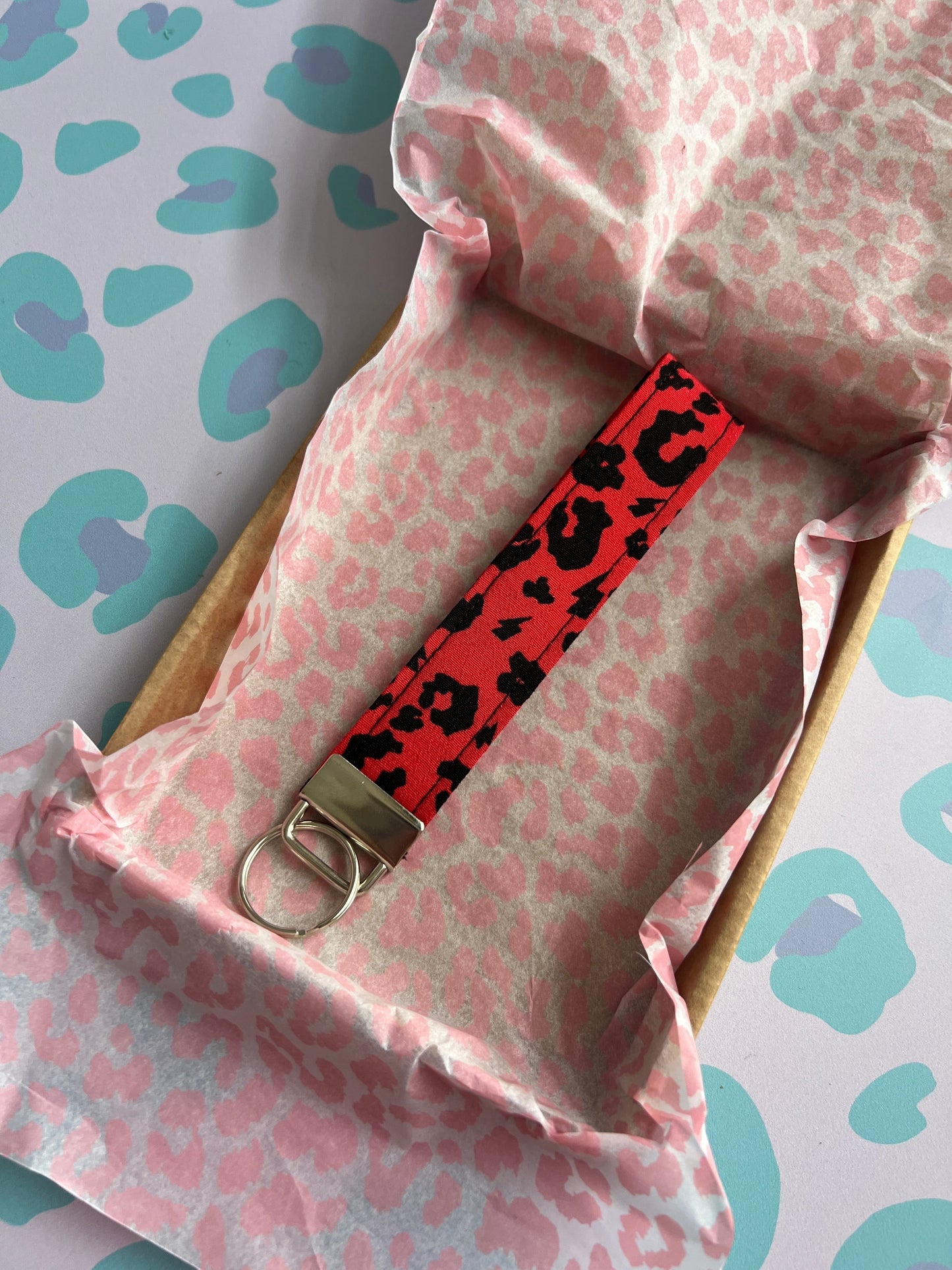 Sew Much Love red leopard print fabric wristlet keychain with silver hardware.