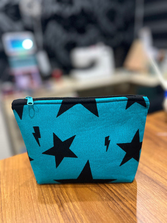Sew Much Love teal mini cosmetic bag with black stars and lightning bolts, black zip, and green pull.
