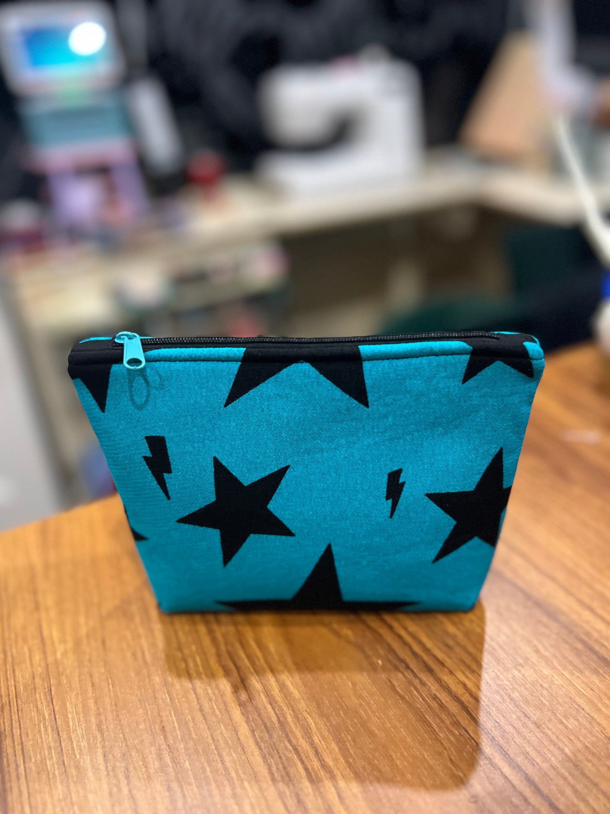 Sew Much Love teal mini cosmetic bag with black stars and lightning bolts, black zip and green pull.